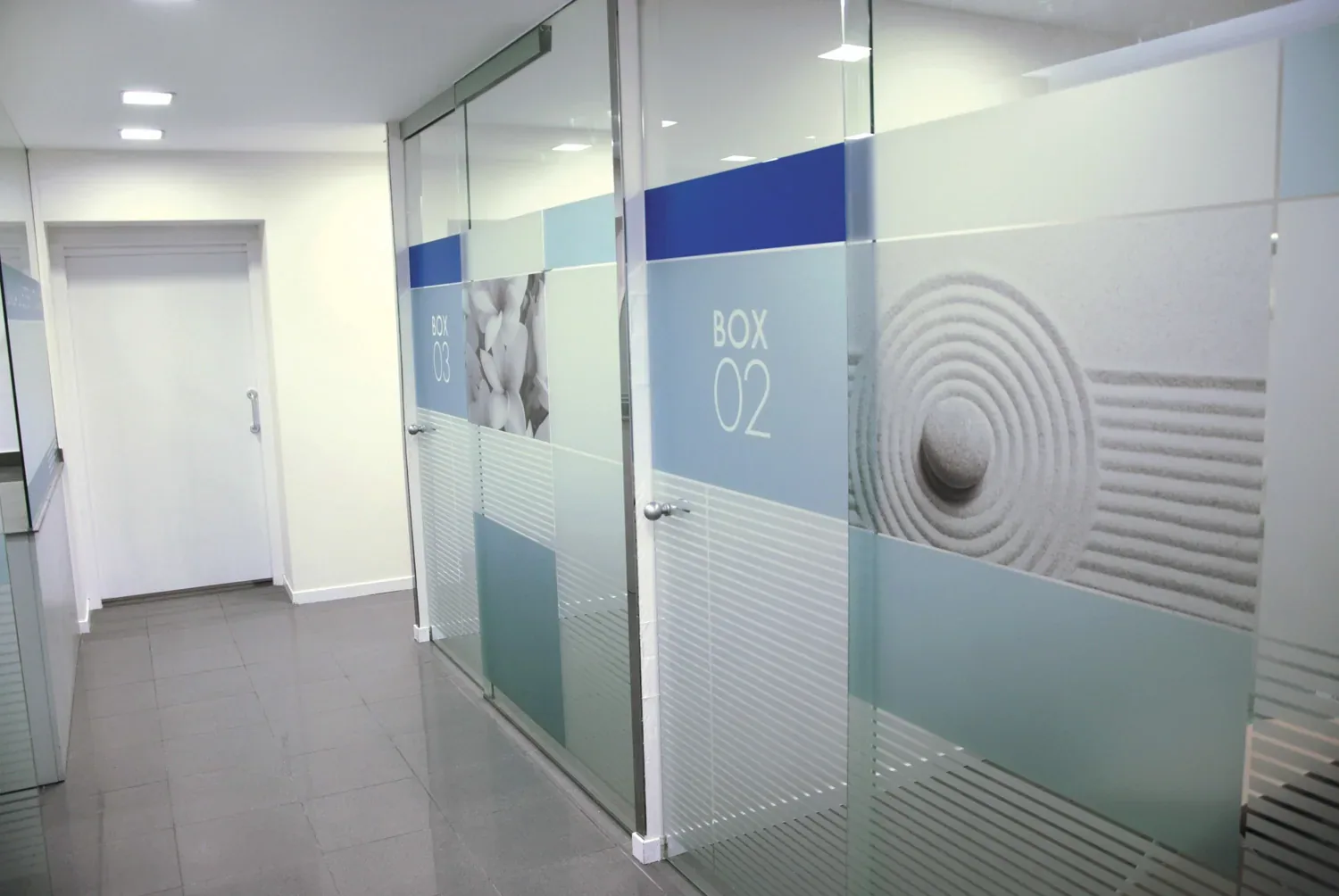 Cristaleras de oficinas decoradas con vinilo al ácido, combinando zonas lisas, impresas y cortadas, por Àbac Rètols.